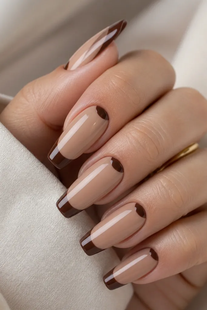 Coffin nails with sheer nude base. The French tips are glossy chocolate brown. Near the cuticle, there's a small half-moon in the same brown, leaving the rest nude.