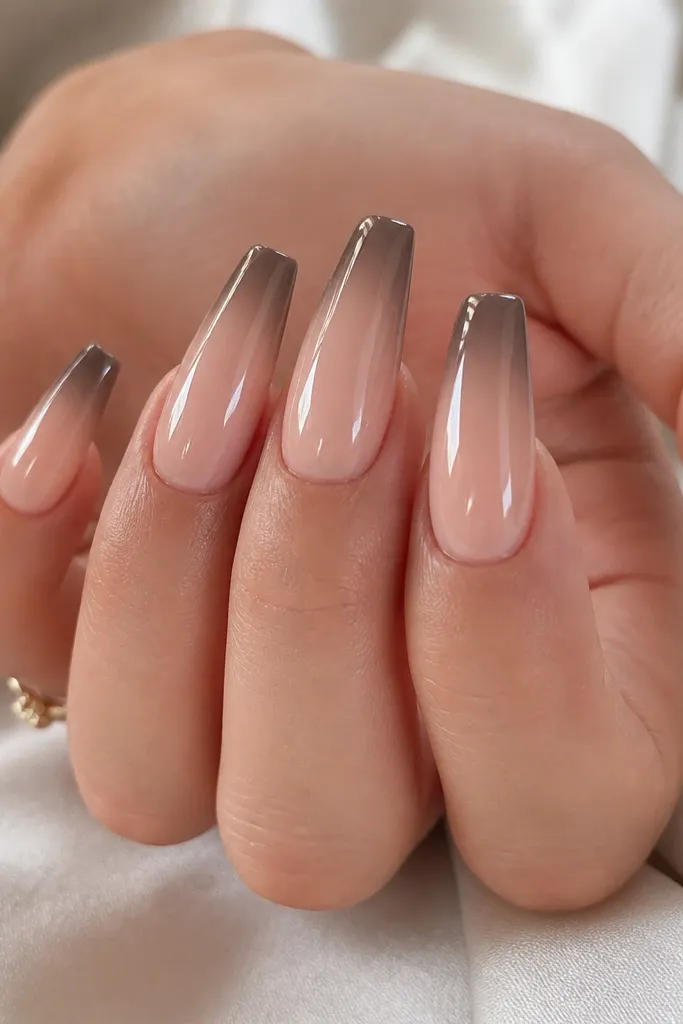 Coffin nails with a nude base. The French tip fades from deeper brown at the very edge into lighter taupe as it moves toward the middle of the nail. The fade is smooth, with glossy top coat.