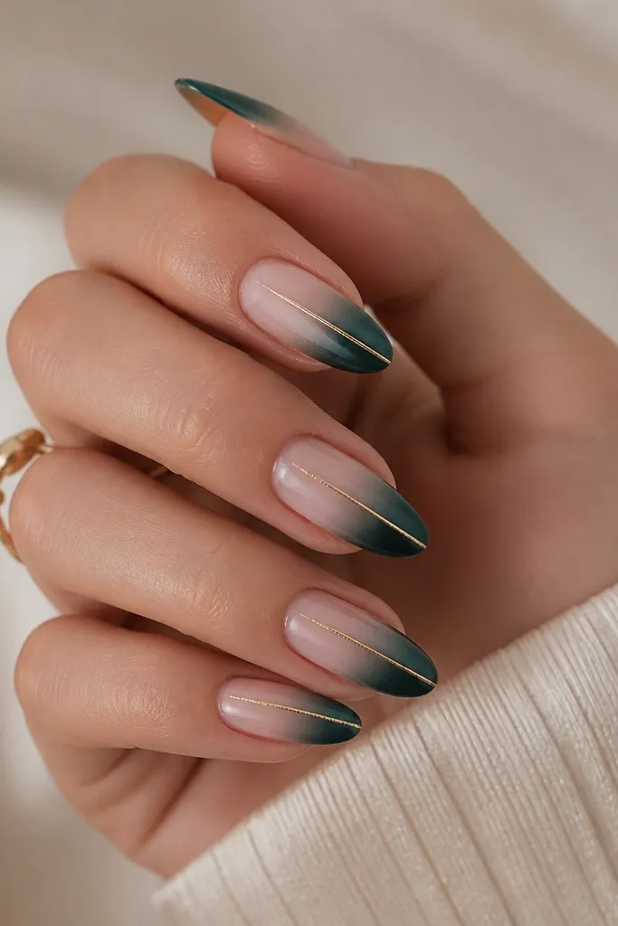 Nails with nude base and emerald gradient at the tip, with a single thin gold line running down the center.