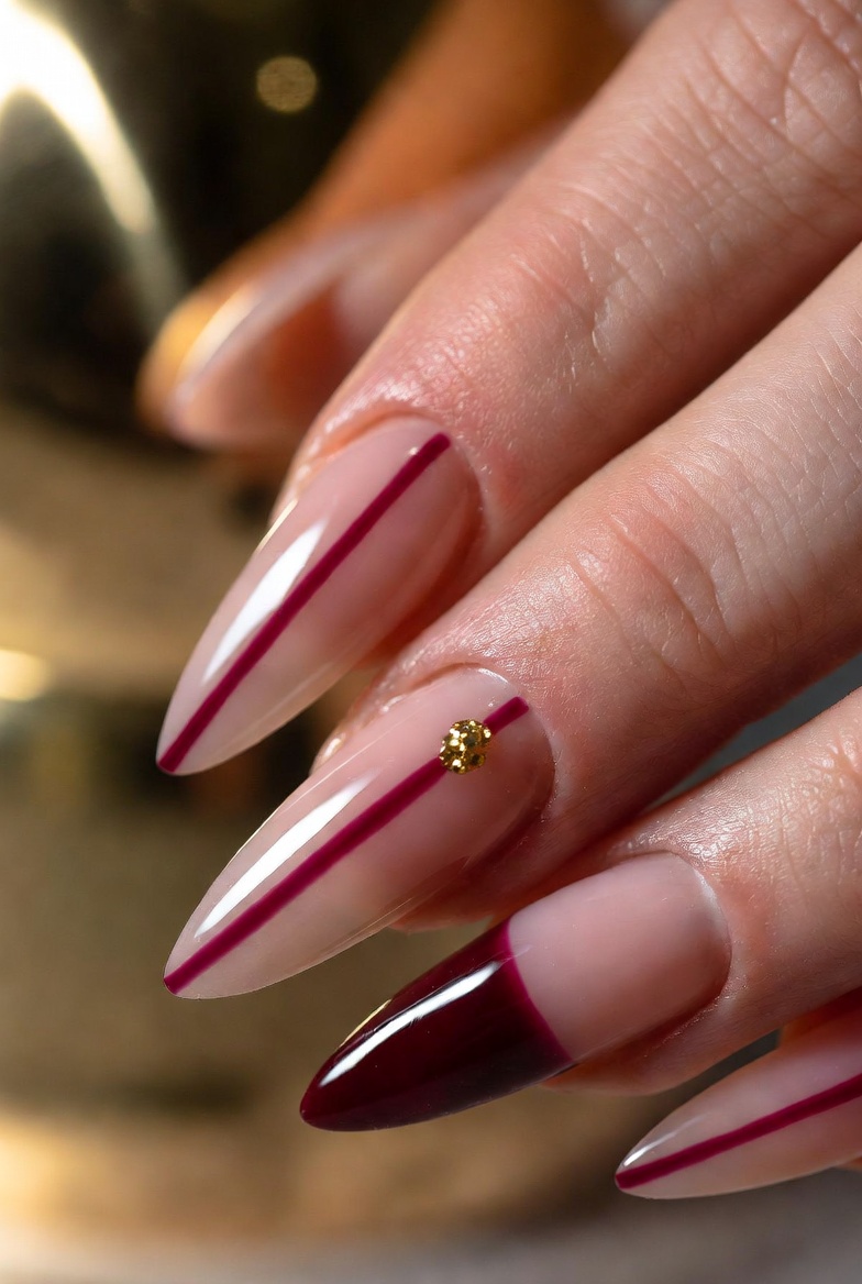 Nails are sheer nude with a thick deep burgundy stripe running vertically near one sidewall on each nail. The stripe has clean edges and ends about 1 mm from the tip. One accent nail has a tiny gold dot at the midpoint.