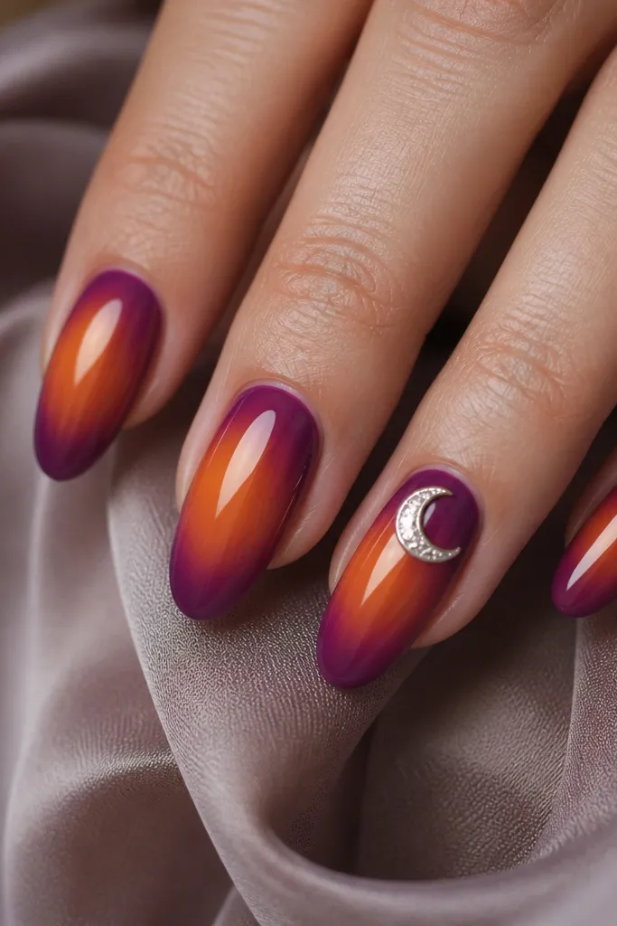 Glossy nails with an aura that fades from warm orange at the sides into berry purple near the edges. One accent nail has a silver foil crescent moon near the cuticle, angled slightly.