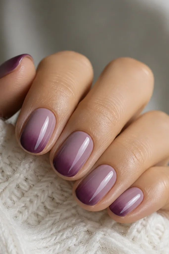 Short oval nails with a mauve base fading into plum at the very tips. The gradient is concentrated at the free edge, with a soft blur line where the colors meet.