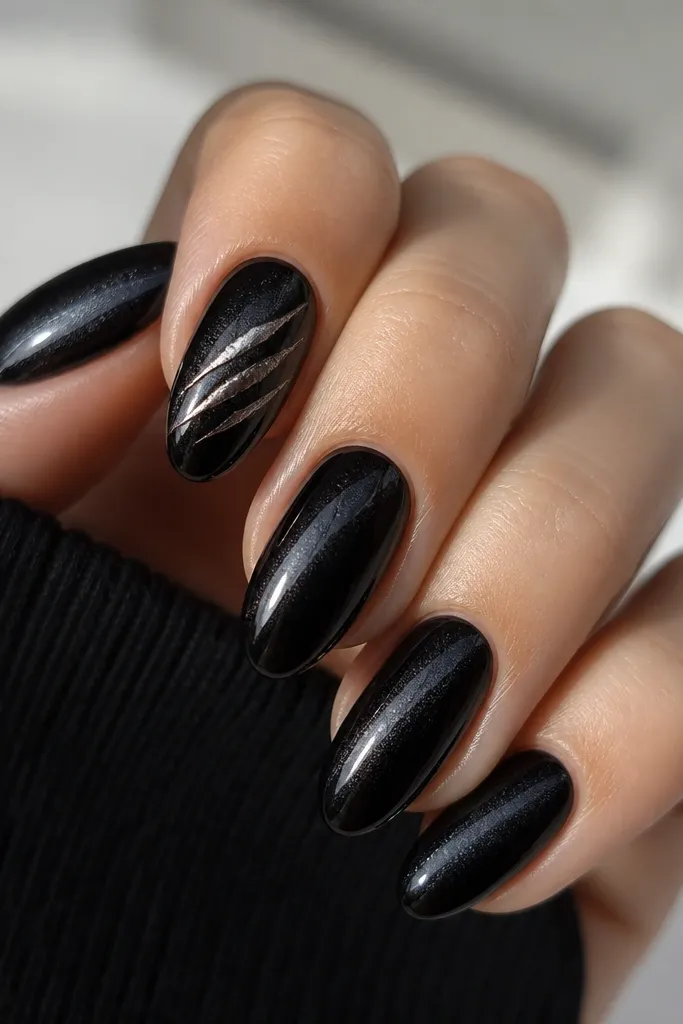 Nails are deep black with a subtle cat-eye shift. A diagonal highlight runs from lower left to upper right on each nail. On the index finger, a single silver claw mark crosses the black near the center.