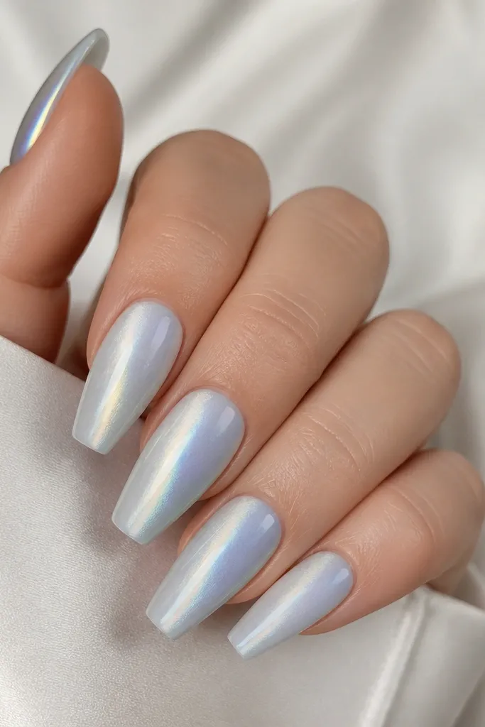 Coffin nails in pearly sky blue with a cat eye stripe that looks silvery; subtle pearlescent glow shifts from cool blue to soft white.