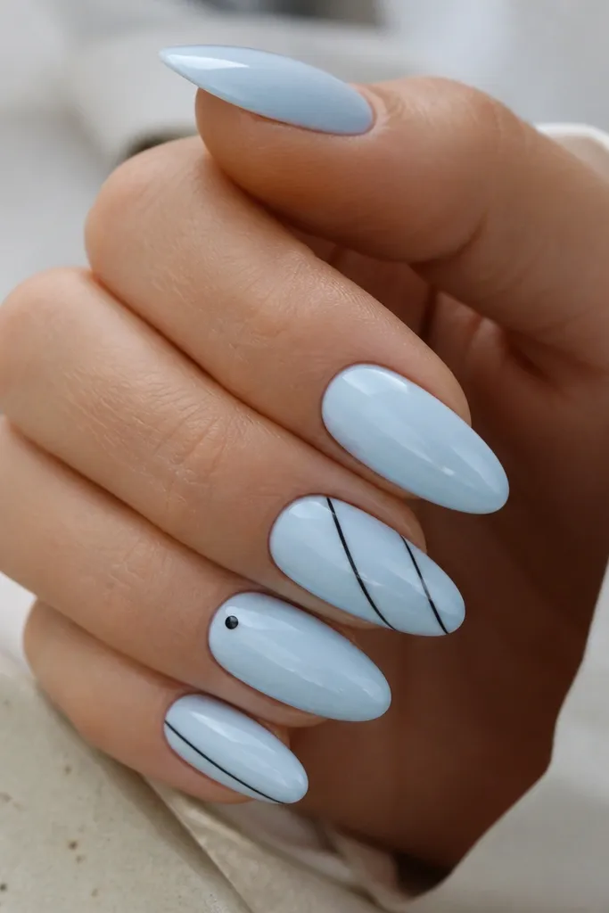 Long almond nails in glossy ice blue. Thin black lines run diagonally in two nails, with one small black dot near the cuticle on another nail.