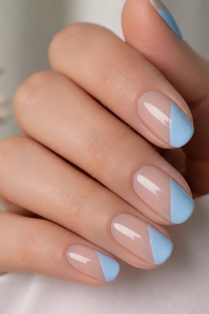 Half the nail is sheer nude with a diagonal sky blue stripe running from lower-left to upper-right. The stripe has crisp edges and a glossy finish.