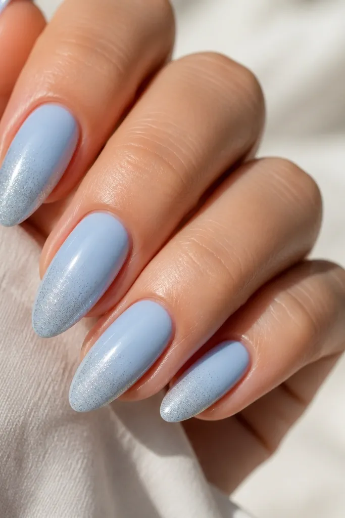 Icy sky blue base with a smooth gradient into ultra-fine silver micro-glitter concentrated at the tip; glitter fades to almost clear near mid-nail.
