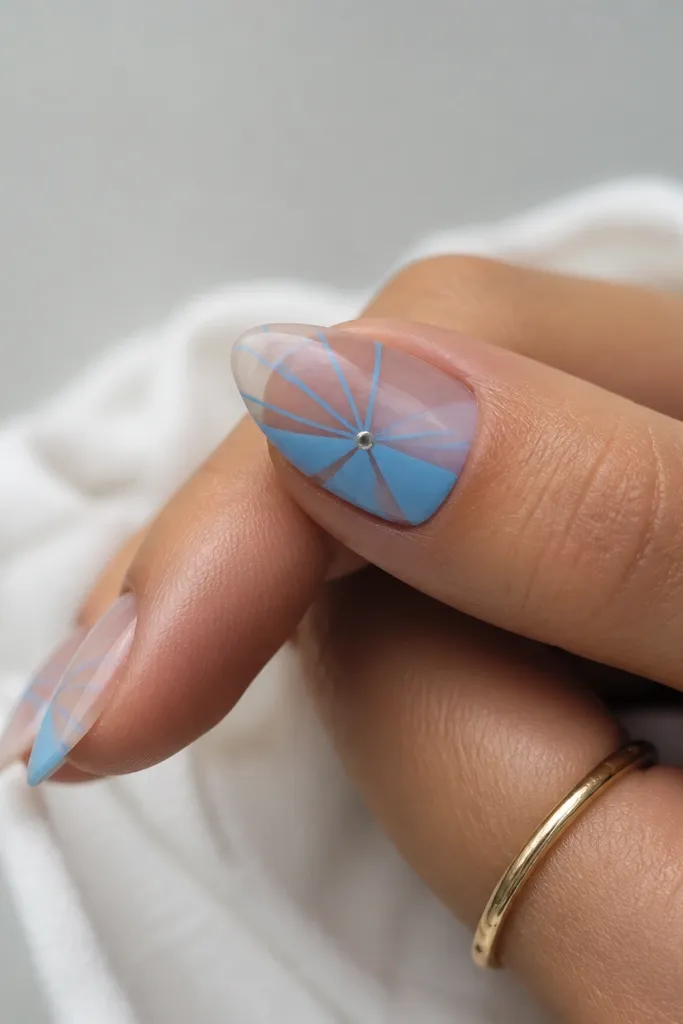 Half the nail is clear nude; sky blue lines form a starburst from the center toward the edges, with one small silver dot at the center.