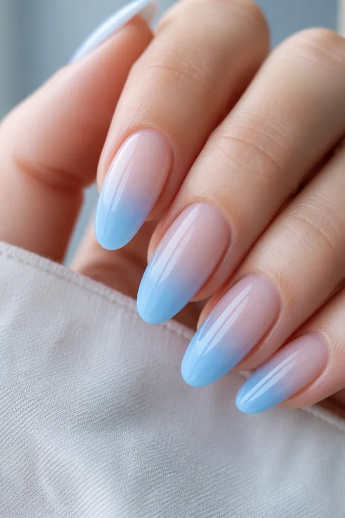 Baby blue ombré from clear near cuticle to deeper sky blue at the tip; ends are extra glossy with a smooth 'cap' layer.