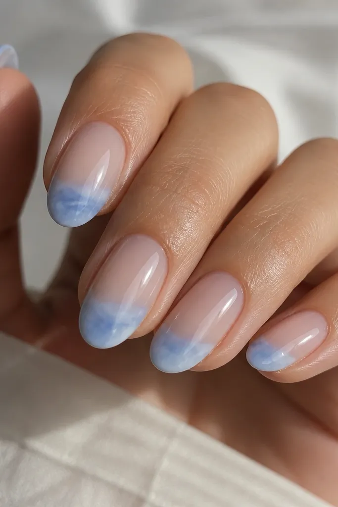 Nails with a milky, cloud-like sky blue tip. The base is sheer nude and the tip looks semi-opaque with a soft edge.