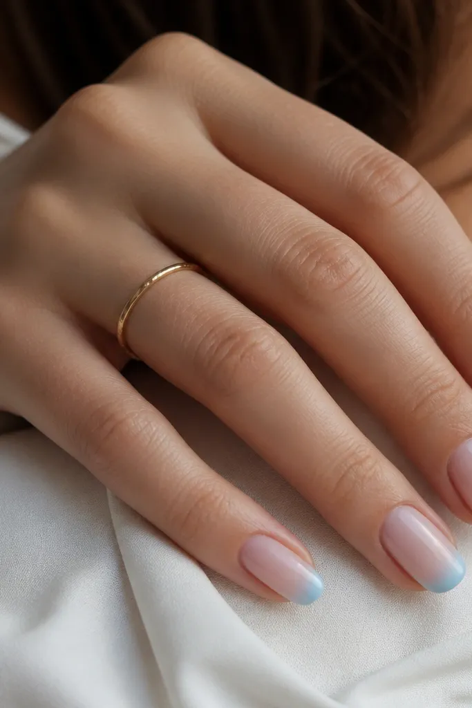 Nails with a French tip that fades from white near the smile into sky blue at the outer edge. Base is nude and the fade is smooth.