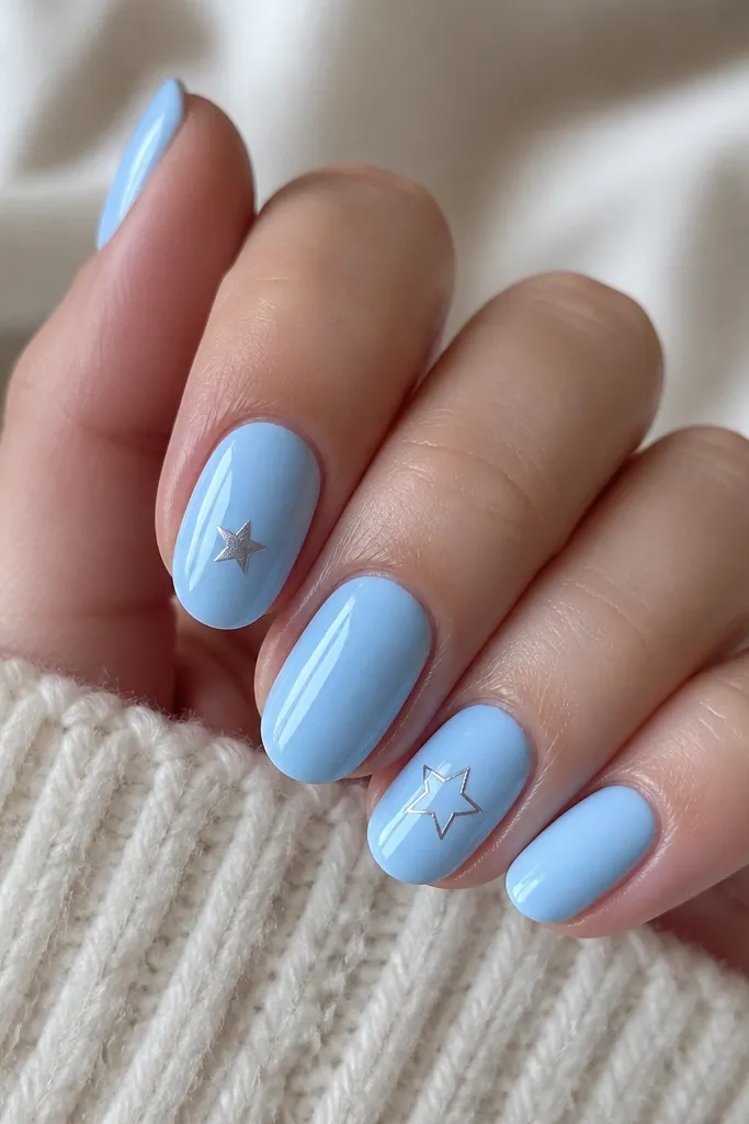 All nails are sky blue glossy. One accent nail has a single tiny silver star near the center, and another has a small star outline. Everything is clean and minimal.
