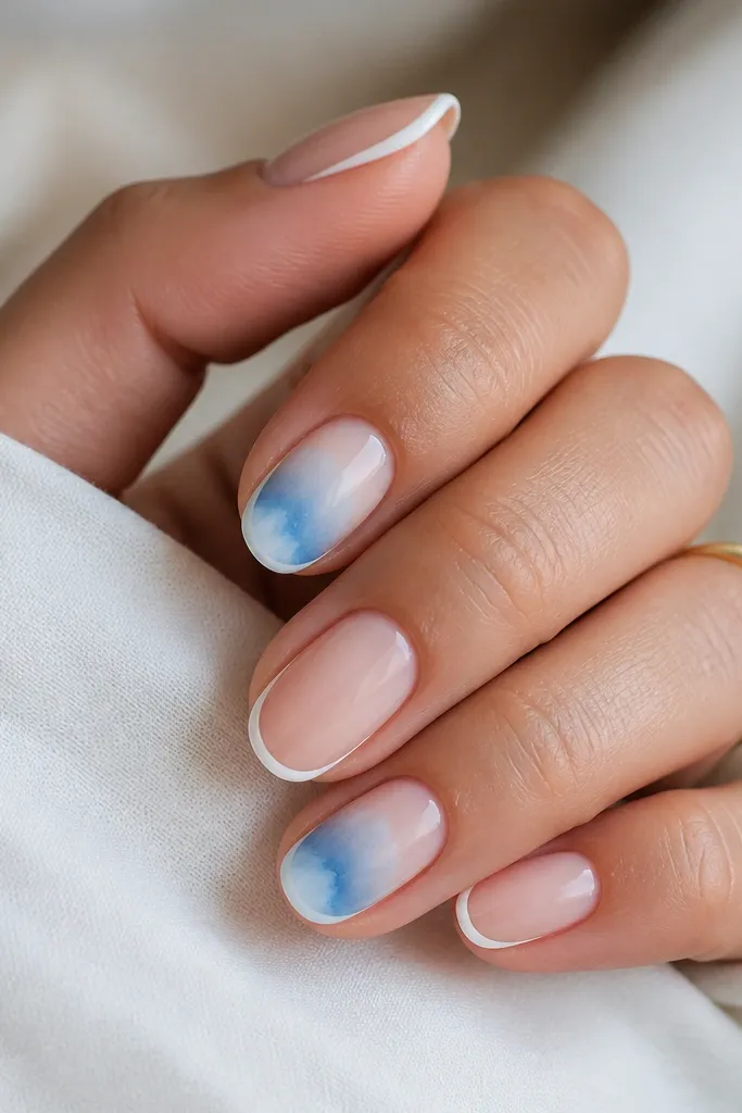 A few nails have a watercolor wash of sky blue that fades outward like paint. Thin white borders trace the nail edges, giving a framed look.