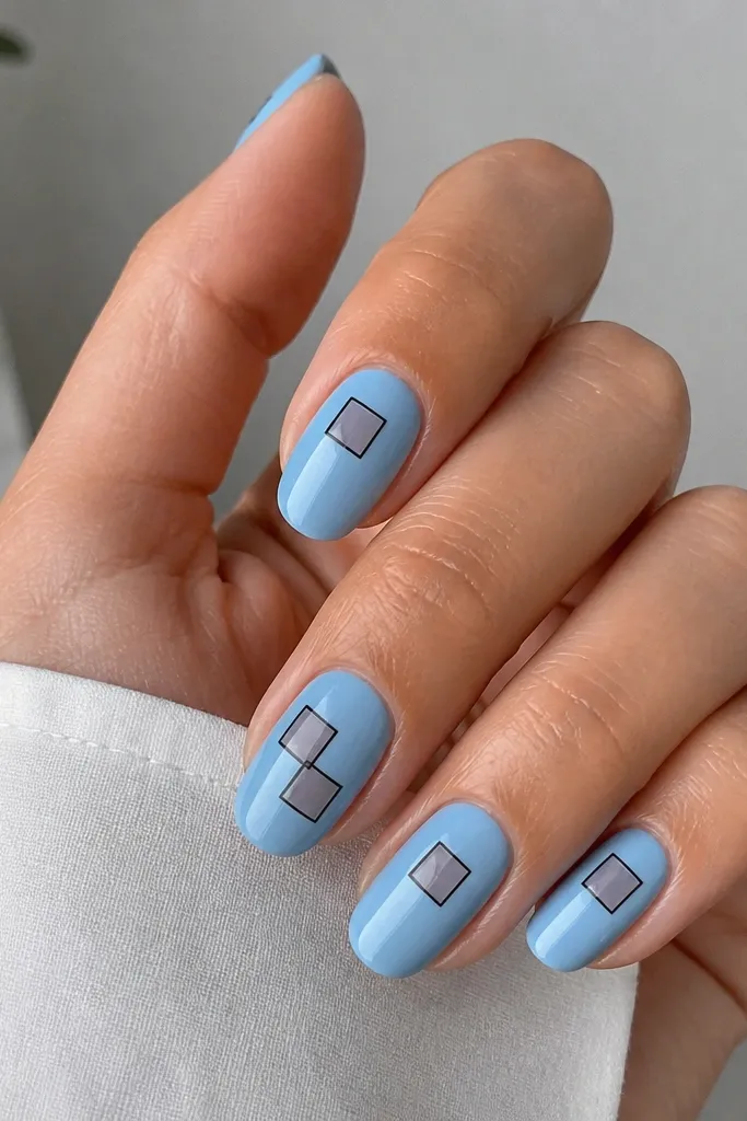 Sky blue nails with two or three small translucent square sections outlined in dark blue or black, glossy and slightly dimensional.