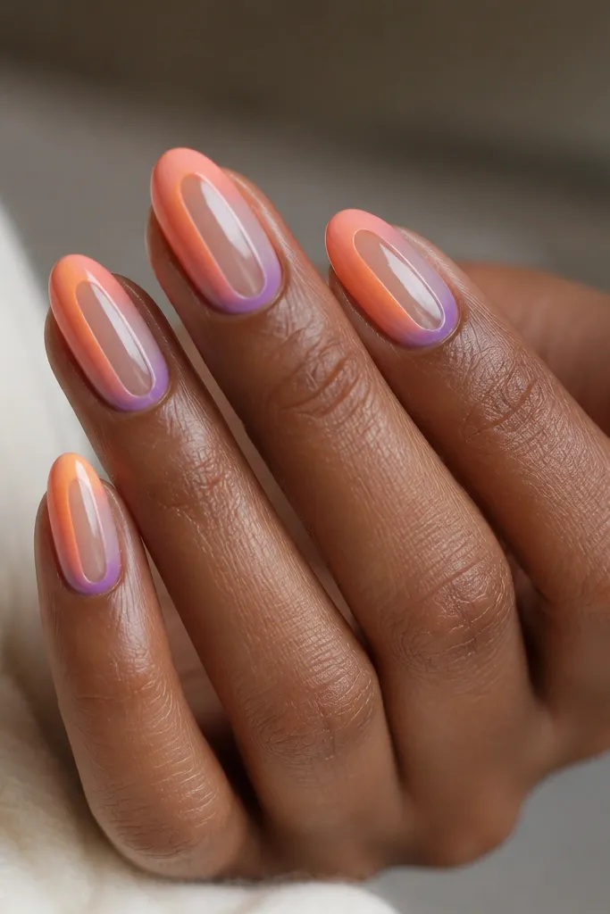 Oval nails with a clear center strip. Around it, there's a sunset gradient in bands: peach, orange, and violet. The clear section gives a modern cutout look, and the topcoat is glossy.