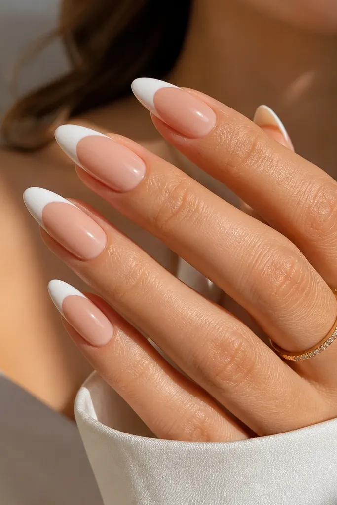Almond nails with creamy white French tips; the cuticle area fades from warm nude into a slightly lighter nude gradient; glossy finish.