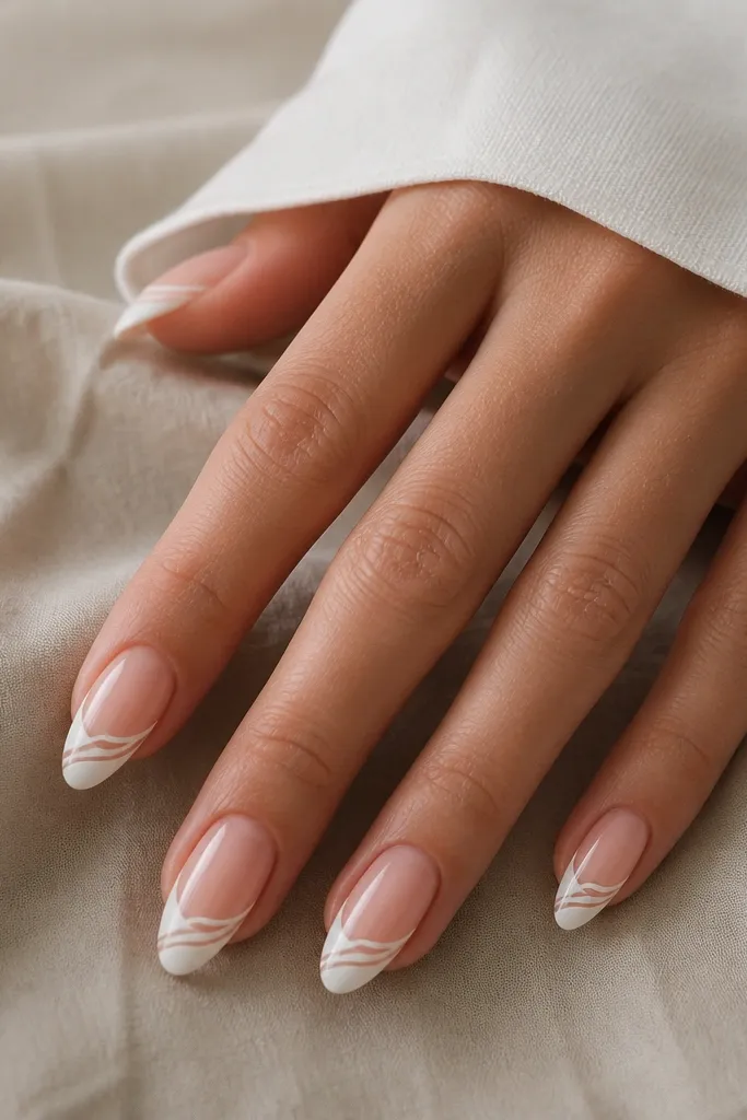 Almond nails with a glossy white French tip. Over the white tip area, there are thin, curved swirl lines that look hand-drawn and slightly varied in thickness.