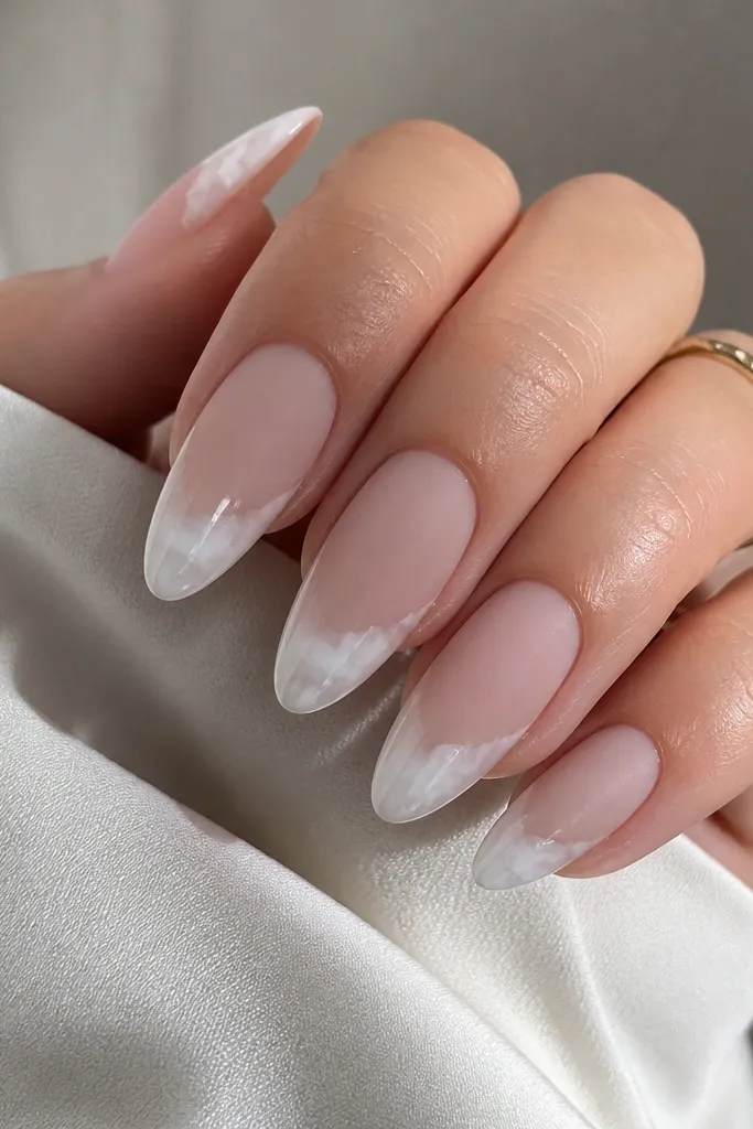 Almond nails with a matte pink-beige base. The French tips are white and slightly cloudy at the edges, like soft clouds. The tips are glossy while the base stays matte.