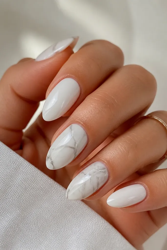 White almond nails with wispy marble streaks. The gray lines look like smoke under glass, mostly on the ring and middle fingers.