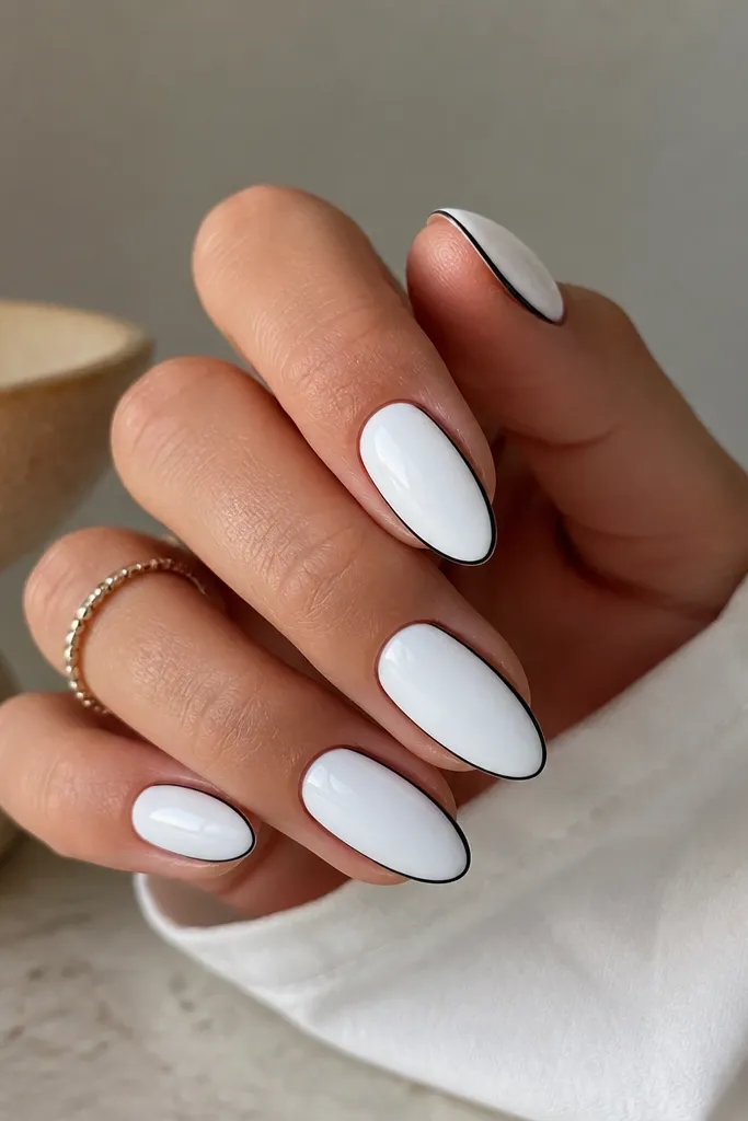 White almond nails with thin black outlines along each sidewall. The outline forms a subtle frame, and the center stays solid white.