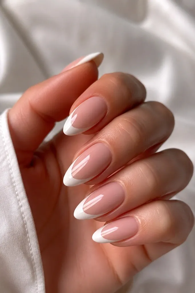 Almond nails with a white French tip and a thin clear (or sheer) outline around the tip edge. The outline makes the white look separated and clean, glossy overall.