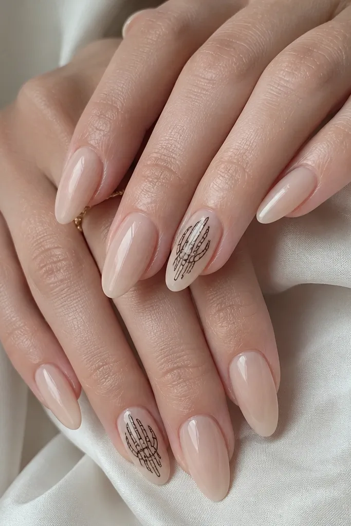 Nude almond nails with one accent nail per hand showing a thin black skeleton hand outline near the center. The outlines look like line art with crisp edges.